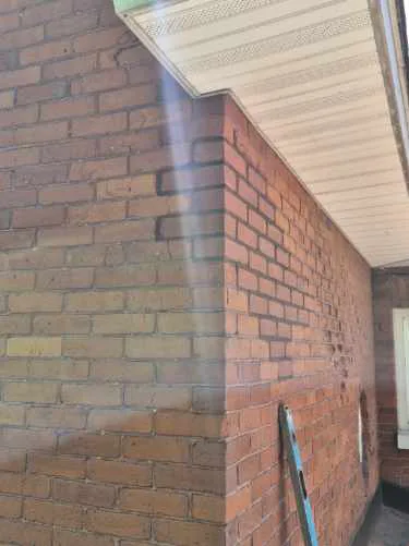 Finished corner of a century home brick repair with mortar joints tooled to match